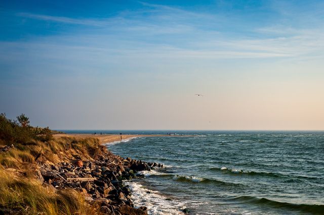 Rocky breakwater curving along the exposed Baltic coast at the end of the Hel Peninsula.