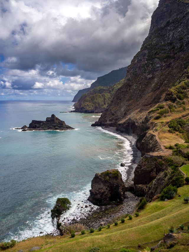 A sheltered turquoise cove and rugged sea stacks beneath Madeira's high northern cliffs.