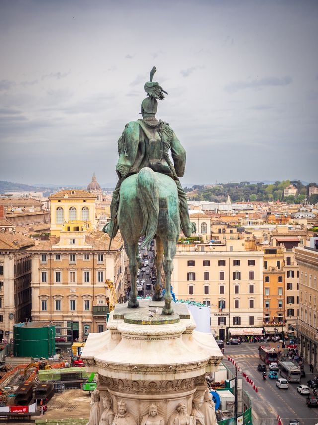 Bronze equestrian monument rising above Rome's dense terracotta rooftops.