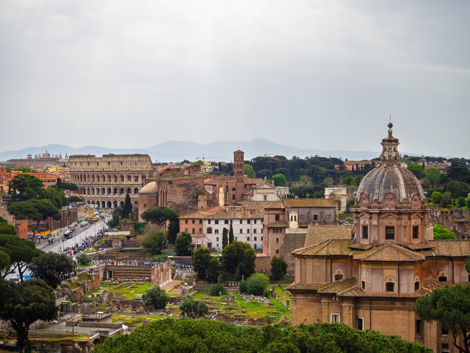 Church domes, civic towers, and the Roman Forum spreading across the city beneath a soft gray sky.