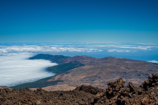 High view across Teide's brown caldera ridges surrounded by a dense layer of cloud.