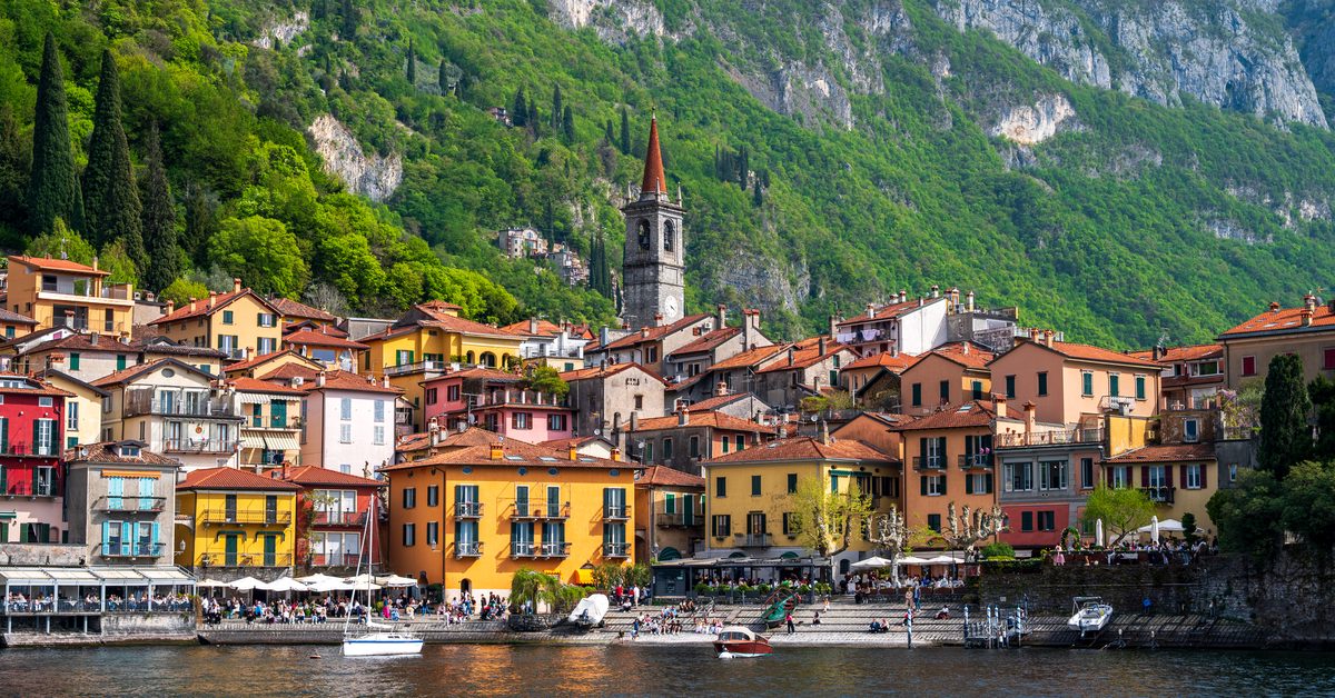 Traditional houses with terracotta roofs cluster along Varenna’s waterfront beneath steep green mountains. Cafés, boats and the prominent church tower bring life to this picturesque village on the eastern shore of Lake Como.