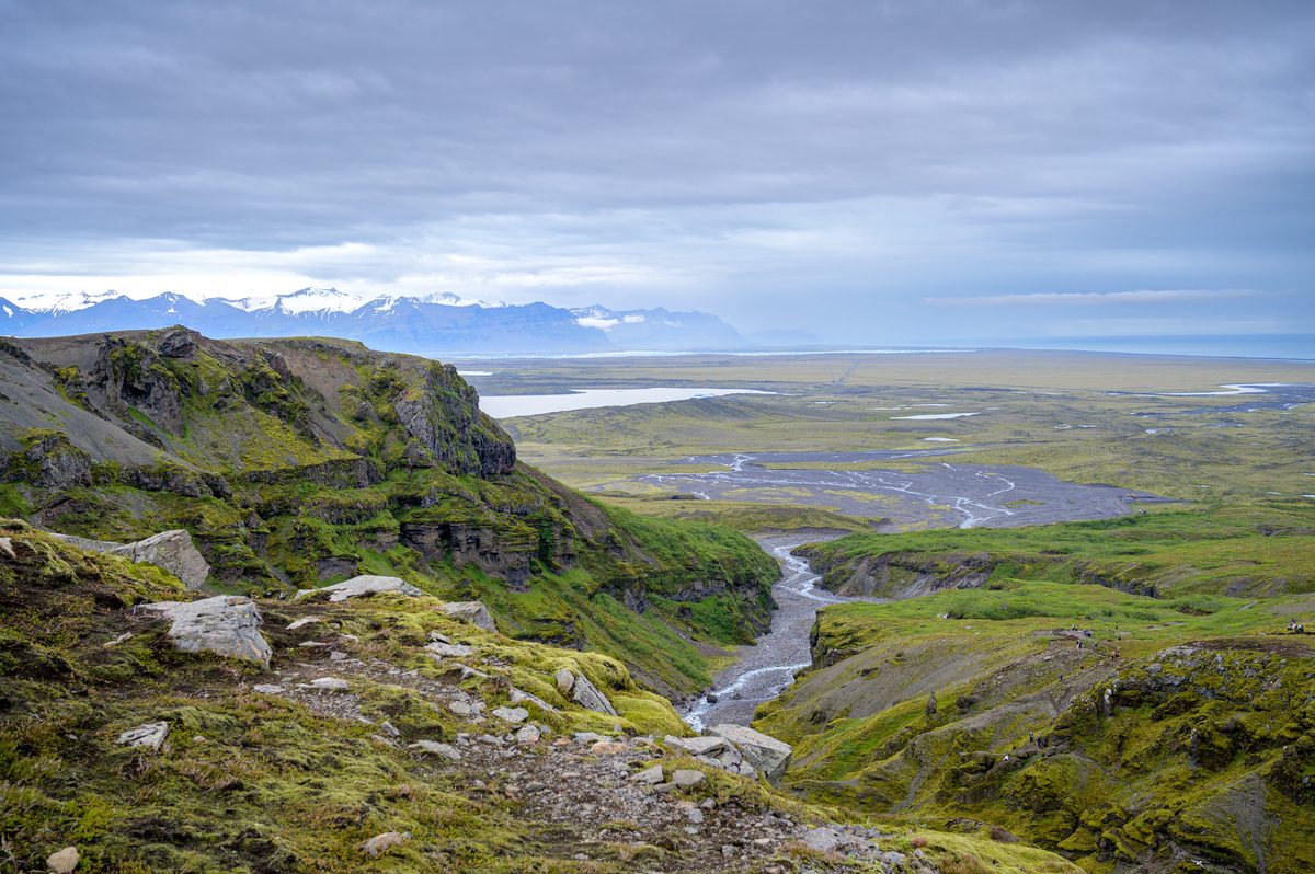 From a high rocky ledge, the canyon river winds outward across the immense coastal plain.